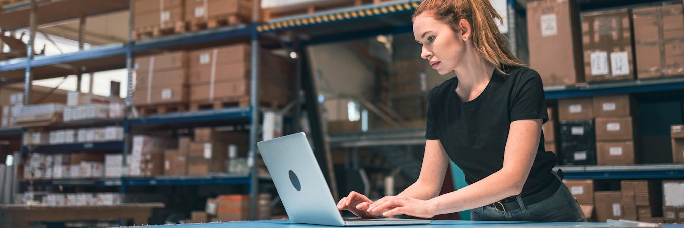 Warehouse manager working on a laptop